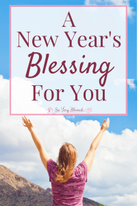 A photo of Becky at the top of the mountain, raising both her hands up with a text overlay that reads as 'A New Year's Blessing For You' : So Very Blessed - Step into the new year full of hope, truth, encouragement, and great expectations with this New Year's blessing.