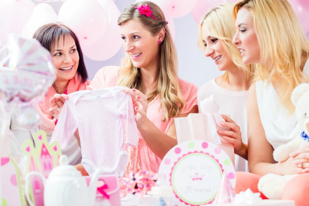 Baby shower prayers - expectant mom opening gift at a baby shower with friends around
