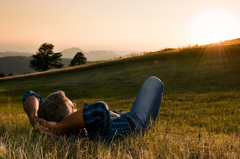 Prayers For My Future Wife - Man laying on grassy hill watching sunset