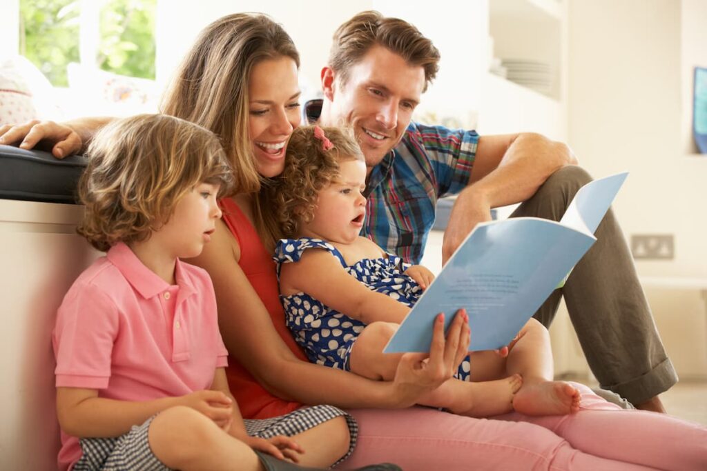 Bible Verses on Teaching Children - Parents sitting down reading a boo to two young children