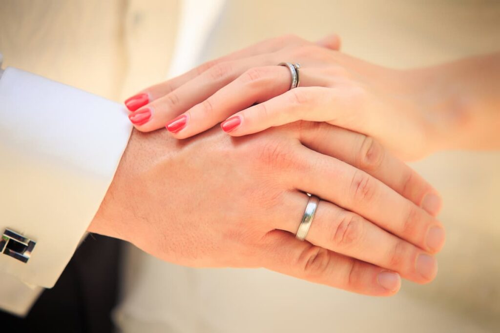Prayers For My Husband - Wife holding her husband's hand with wedding bands showing