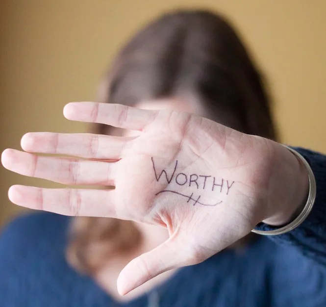 Grow Your Confidence in Christ - woman holding up her hand in front of her face with the word 