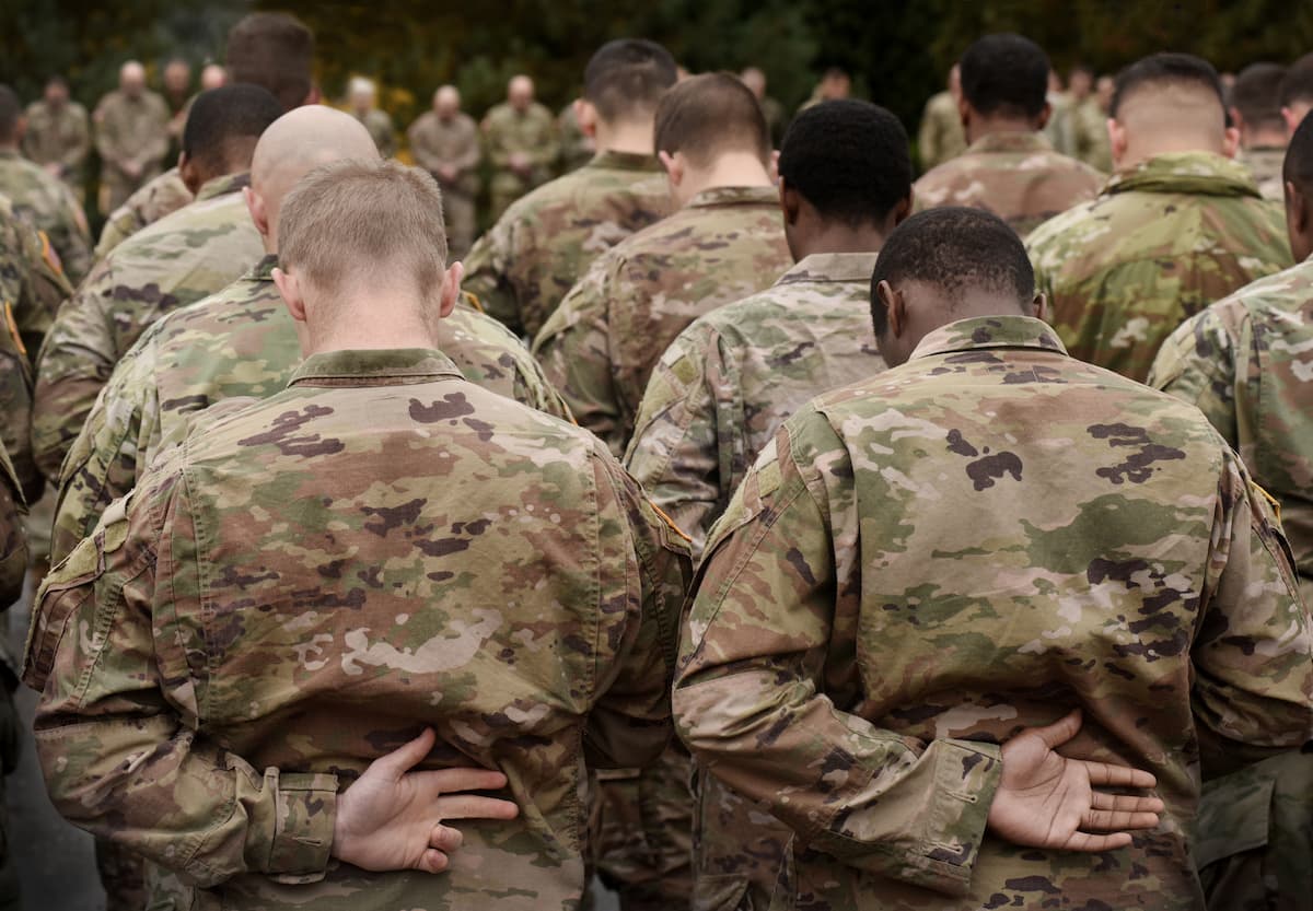Group of US soldiers heads bowed praying