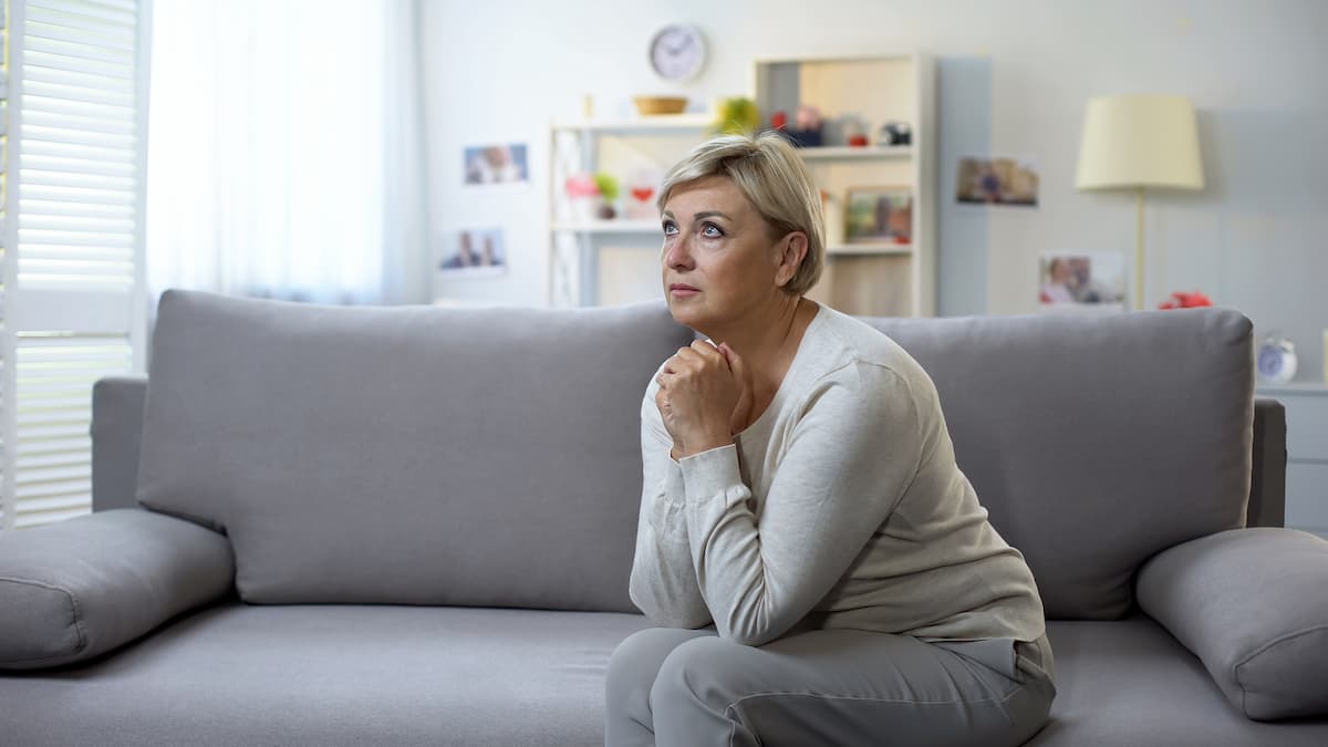 Woman hands clasped saying prayers for better days