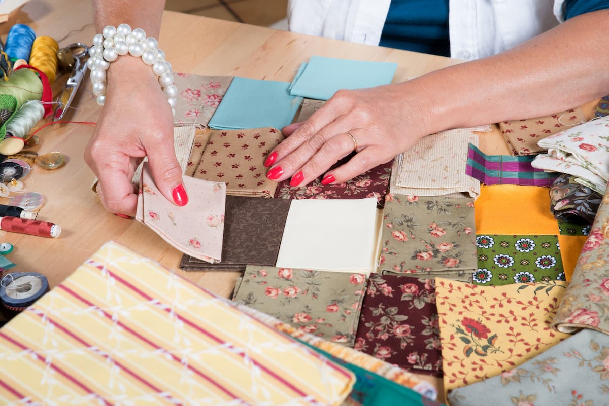 Woman piecing together quilt squares - prayers for quilters