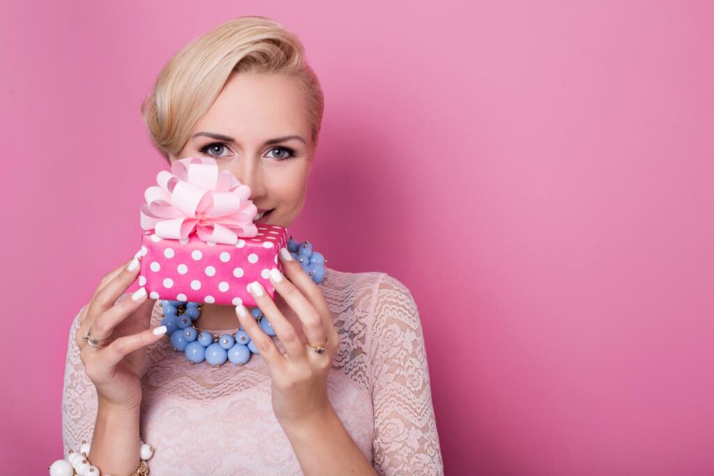 Birthday Prayer for Daughter in Law - sweet blonde woman holding small gift box with ribbon