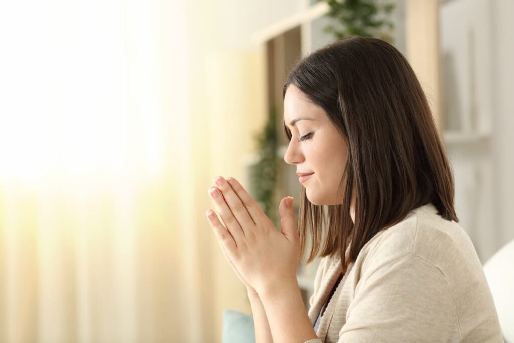Side view of a christian religious woman praying 